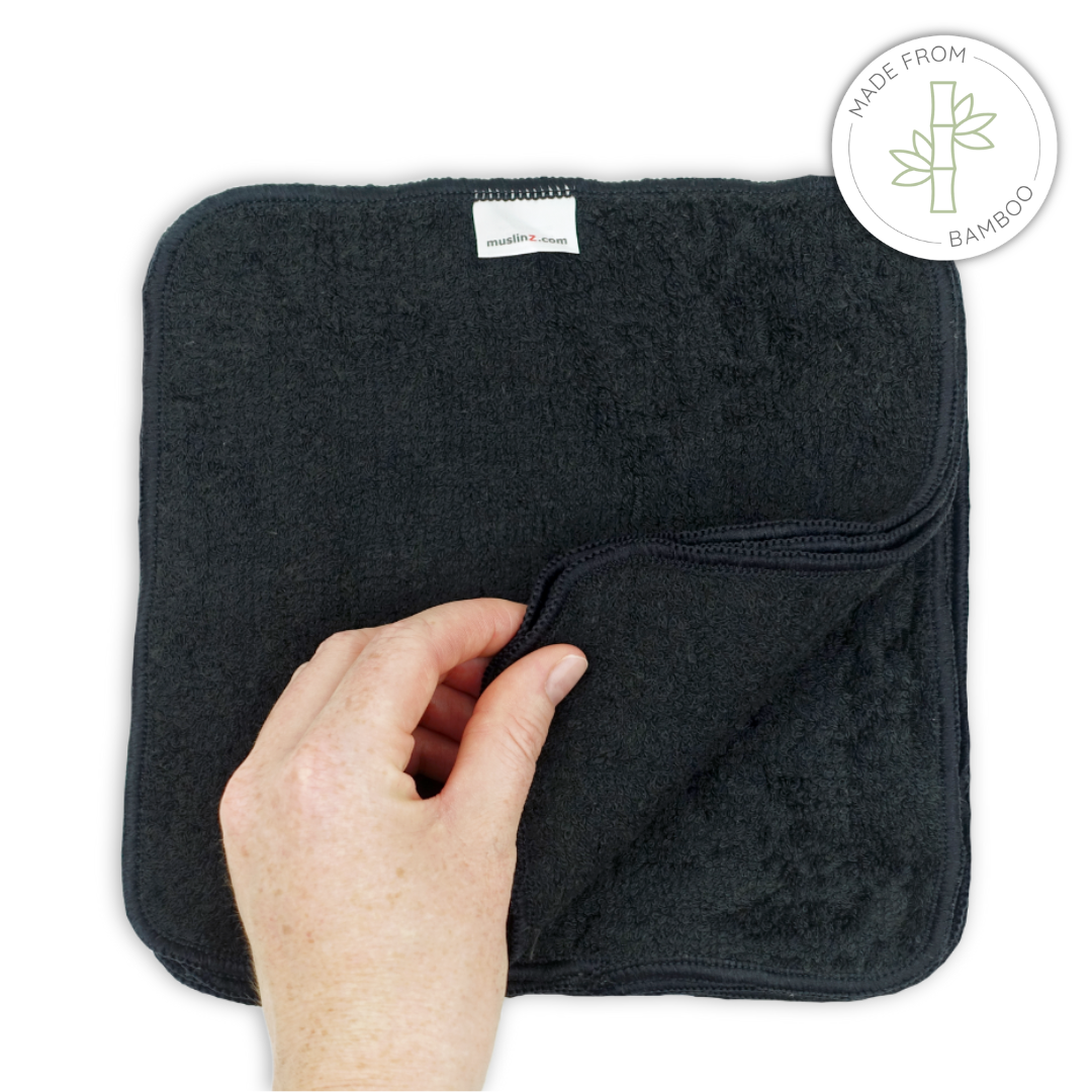Black towel with a hand holding it, branded 'Bamboo', on a white background