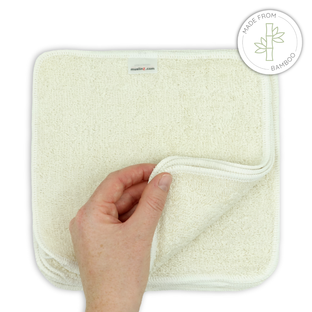 Hand holding a beige towel / wipe with a 'Made from Bamboo' label in the corner.
