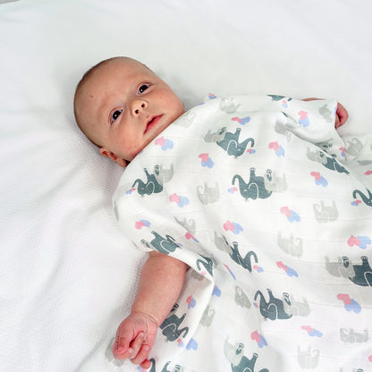 Newborn baby wrapped in a blanket with animal patterns on a white background