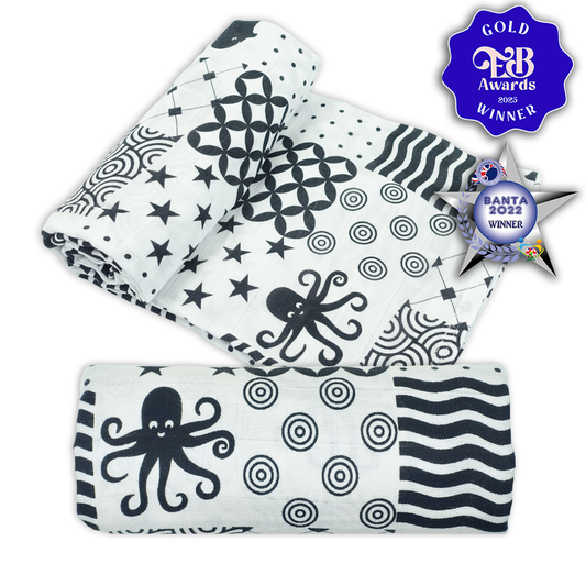 Set of black and white patterned baby blankets with awards on a white background