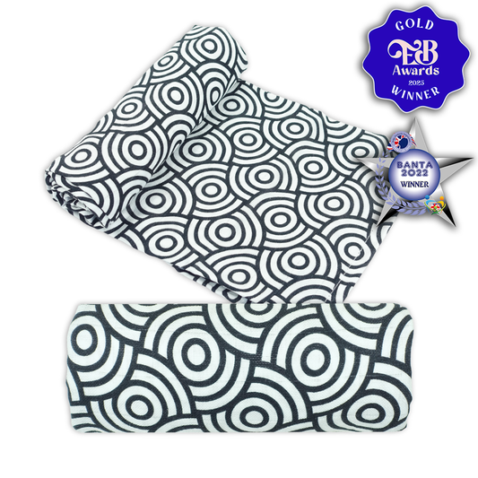 Two black and white patterned baby muslins with awards on a white background