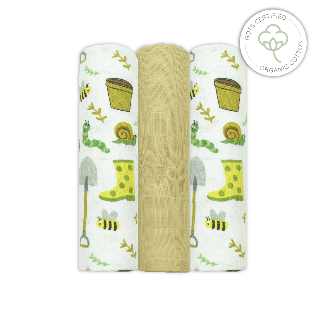 Three swaddle blankets with garden-themed designs on a white background, featuring organic cotton certification.