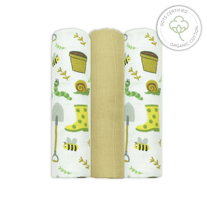 Three swaddle blankets with garden-themed designs on a white background, featuring organic cotton certification.
