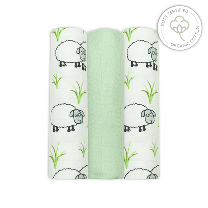 Three swaddle blankets with sheep and grass pattern on a white background, featuring an Organic Cotton certification logo.
