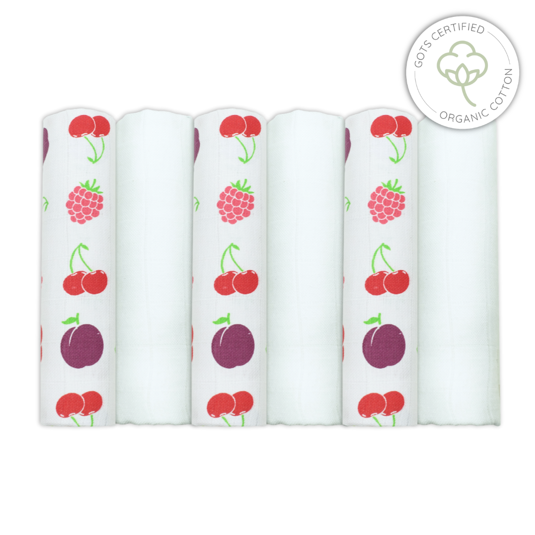 Five white swaddle blankets with fruit patterns on a white background, featuring GO! Certified Organic Cotton logo.