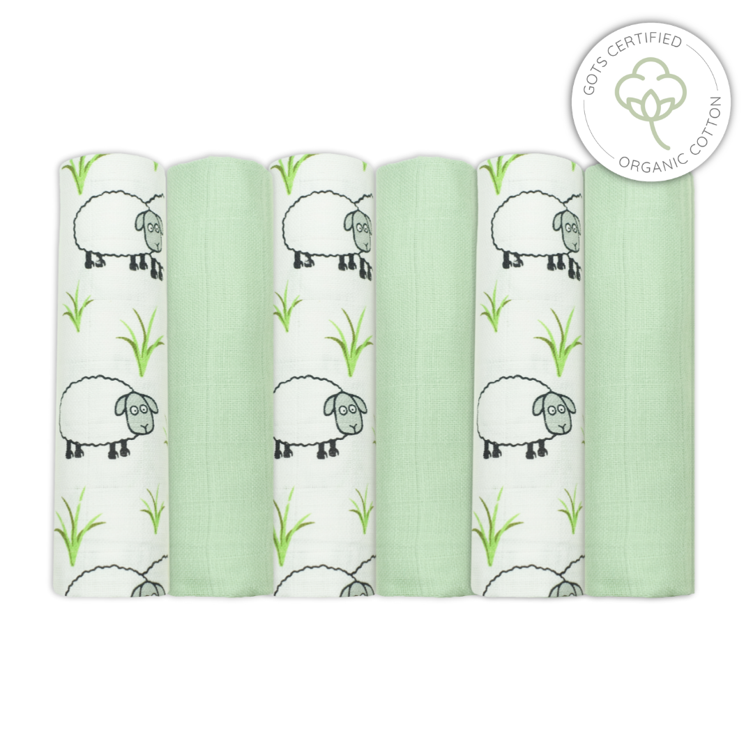 Five green swaddle blankets with sheep patterns on a white background, featuring an Organic Cotton certification logo.