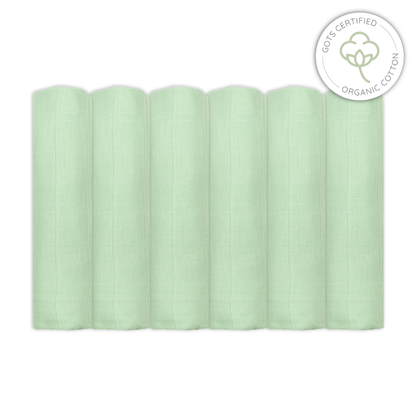 Stack of light sage green baby muslin swaddles with Organic Cotton certification logo on a white background